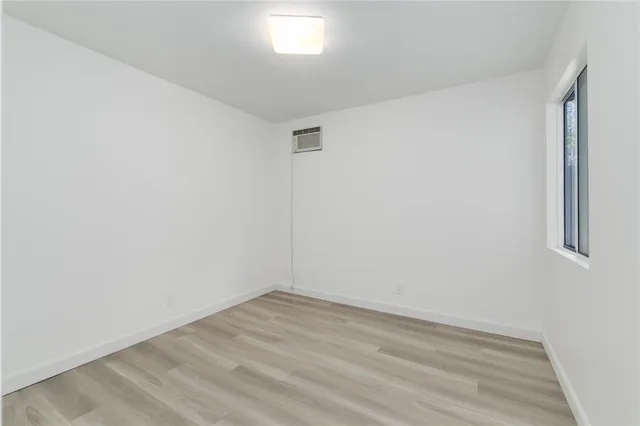 a view of a room with wooden floor and white walls