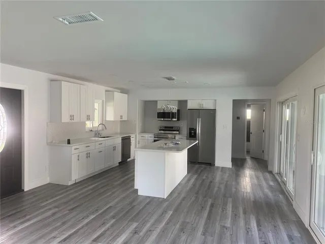 a kitchen with sink cabinets and wooden floor