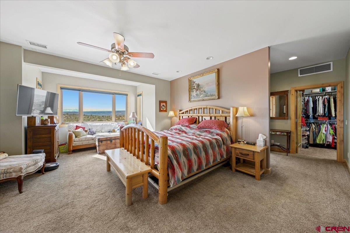 15773 6000th Road Montrose, CO 81403 - Photo 13 of 35 a spacious bedroom with a bed and a chandelier