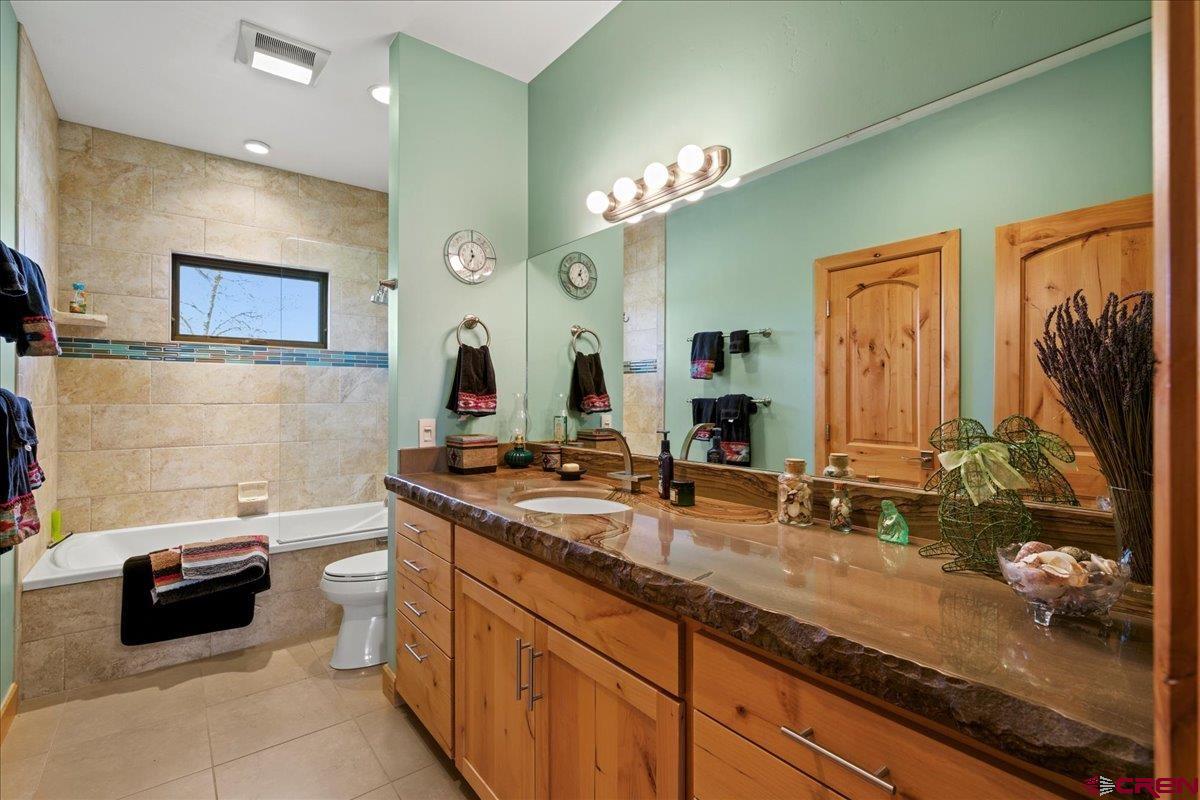 15773 6000th Road Montrose, CO 81403 - Photo 17 of 35 a bathroom with a double vanity sink a mirror and a shower