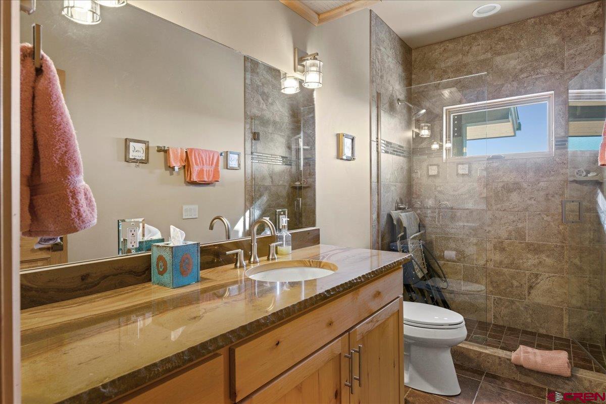 15773 6000th Road Montrose, CO 81403 - Photo 20 of 35 a bathroom with a granite countertop sink mirror vanity and toilet