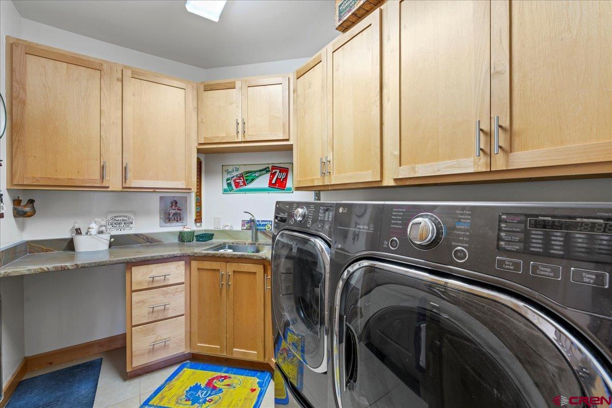 15773 6000th Road Montrose, CO 81403 - Photo 21 of 35 a utility room with stainless steel appliances granite countertop a sink and a washer dryer
