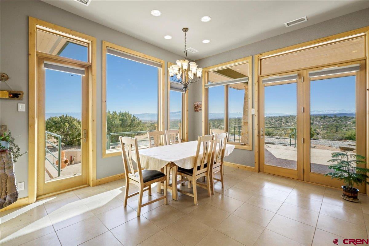 15773 6000th Road Montrose, CO 81403 - Photo 7 of 35 a view of a dining room with furniture large windows and wooden floor