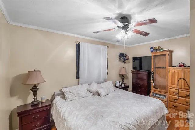 a bedroom with a bed and a flat tv screen on dresser
