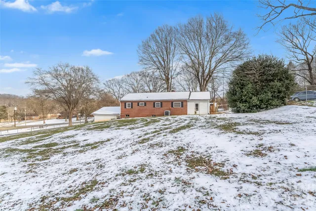 a view of a house with a yard covered in snow