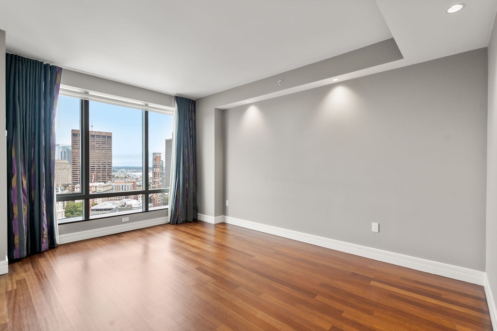 1 Avery Street, Unit 33A Boston, MA 02111 - Photo 22 of 29 a view of an empty room with wooden floor and a window