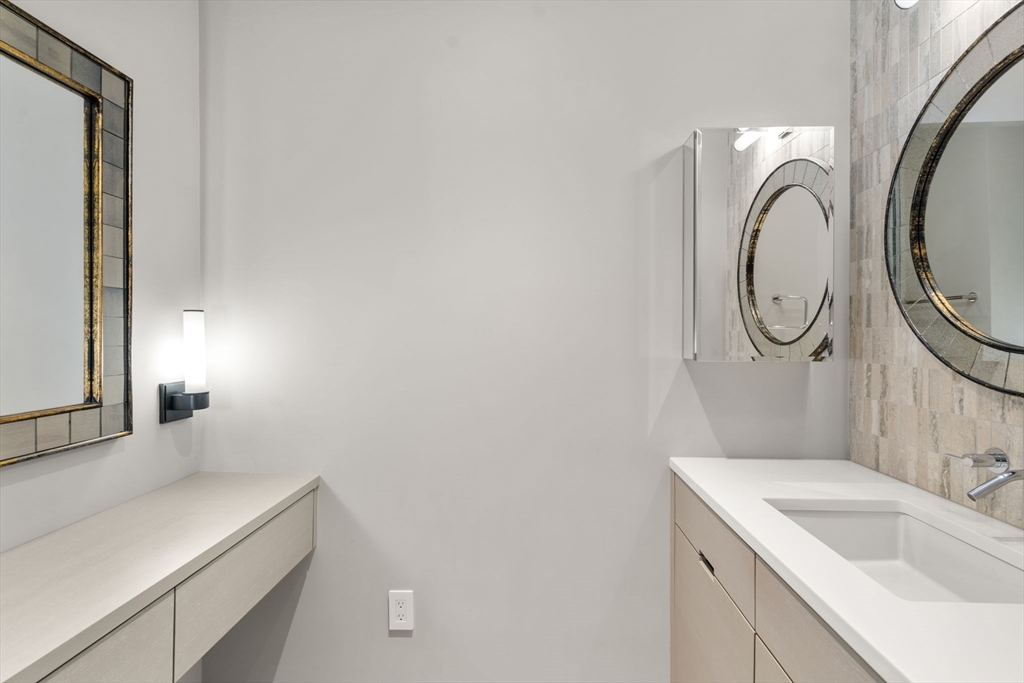 1 Avery Street, Unit 33A Boston, MA 02111 - Photo 25 of 29 a bathroom with a sink and a mirror