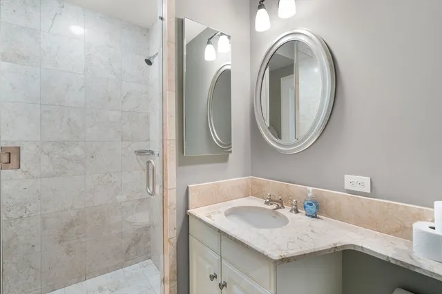 a bathroom with a granite countertop sink and a mirror