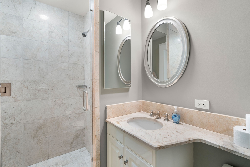 1 Avery Street, Unit 33A Boston, MA 02111 - Photo 26 of 29 a bathroom with a granite countertop sink and a mirror