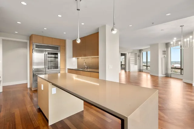 a large kitchen with stainless steel appliances granite countertop a large kitchen island and a wooden floors
