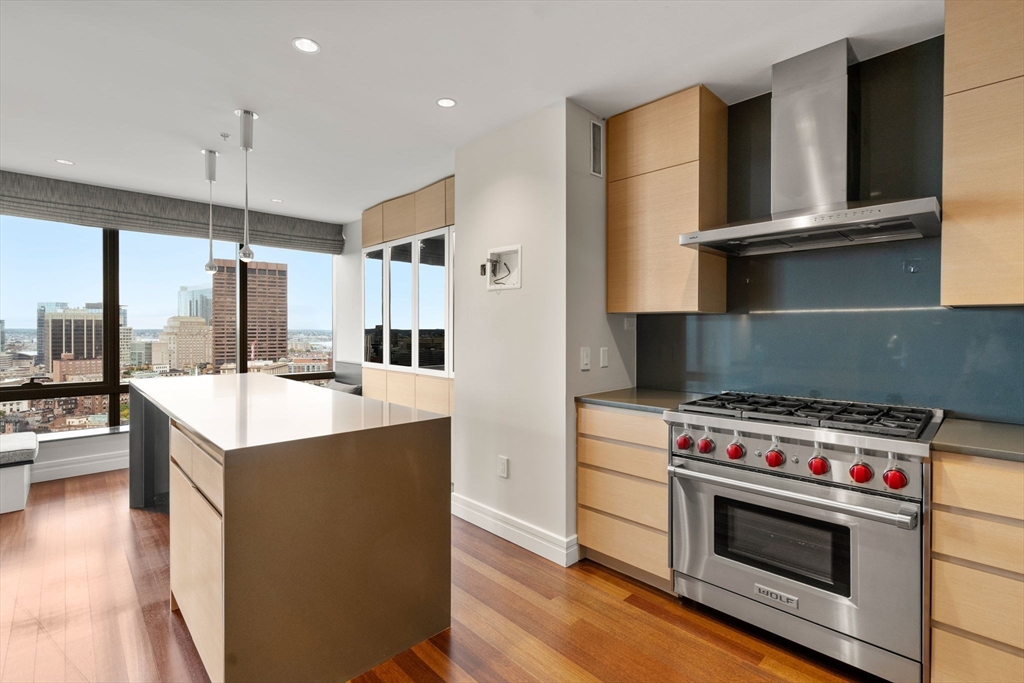 1 Avery Street, Unit 33A Boston, MA 02111 - Photo 7 of 29 a kitchen with kitchen island a stove a sink and a wooden floors