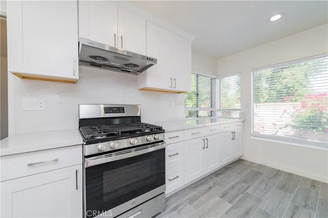 a kitchen with stainless steel appliances granite countertop a stove a sink and a refrigerator