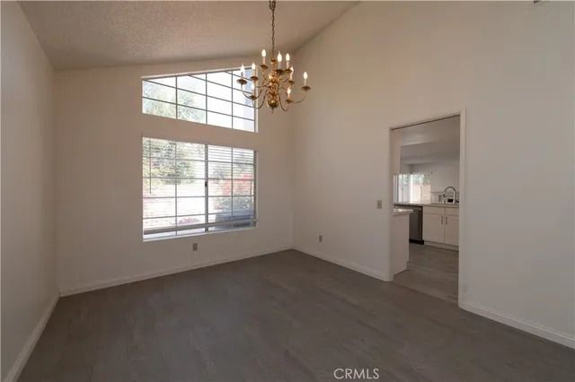 en empty room with windows and chandelier