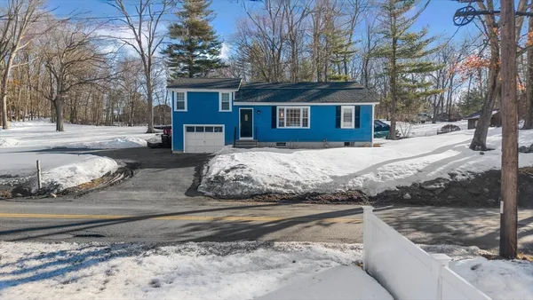 a front view of a house with a yard covered in snow