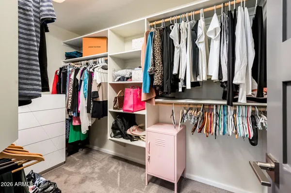 a view of walk in closet with clothes and shoes