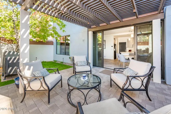 a view of a backyard with table and chairs potted plants and a palm tree