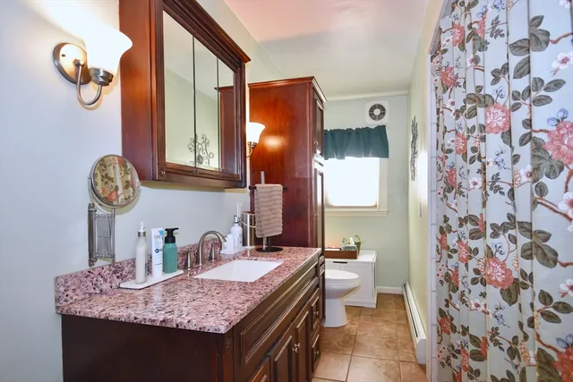 a bathroom with a granite countertop sink a toilet and a mirror