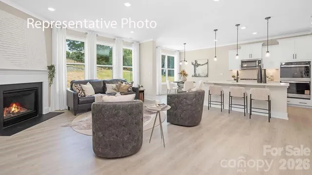 a living room with furniture a fireplace and a kitchen view