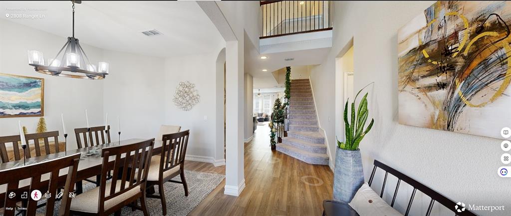 a dining room with furniture potted plants and wooden floor