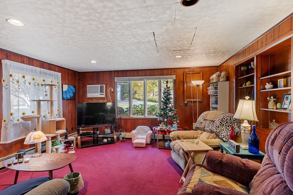 36 Brownlea Road Framingham, MA 01701 - Photo 16 of 24 a living room with furniture a flat screen tv and a floor to ceiling window