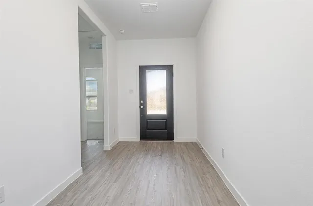 a view of an empty room with wooden floor