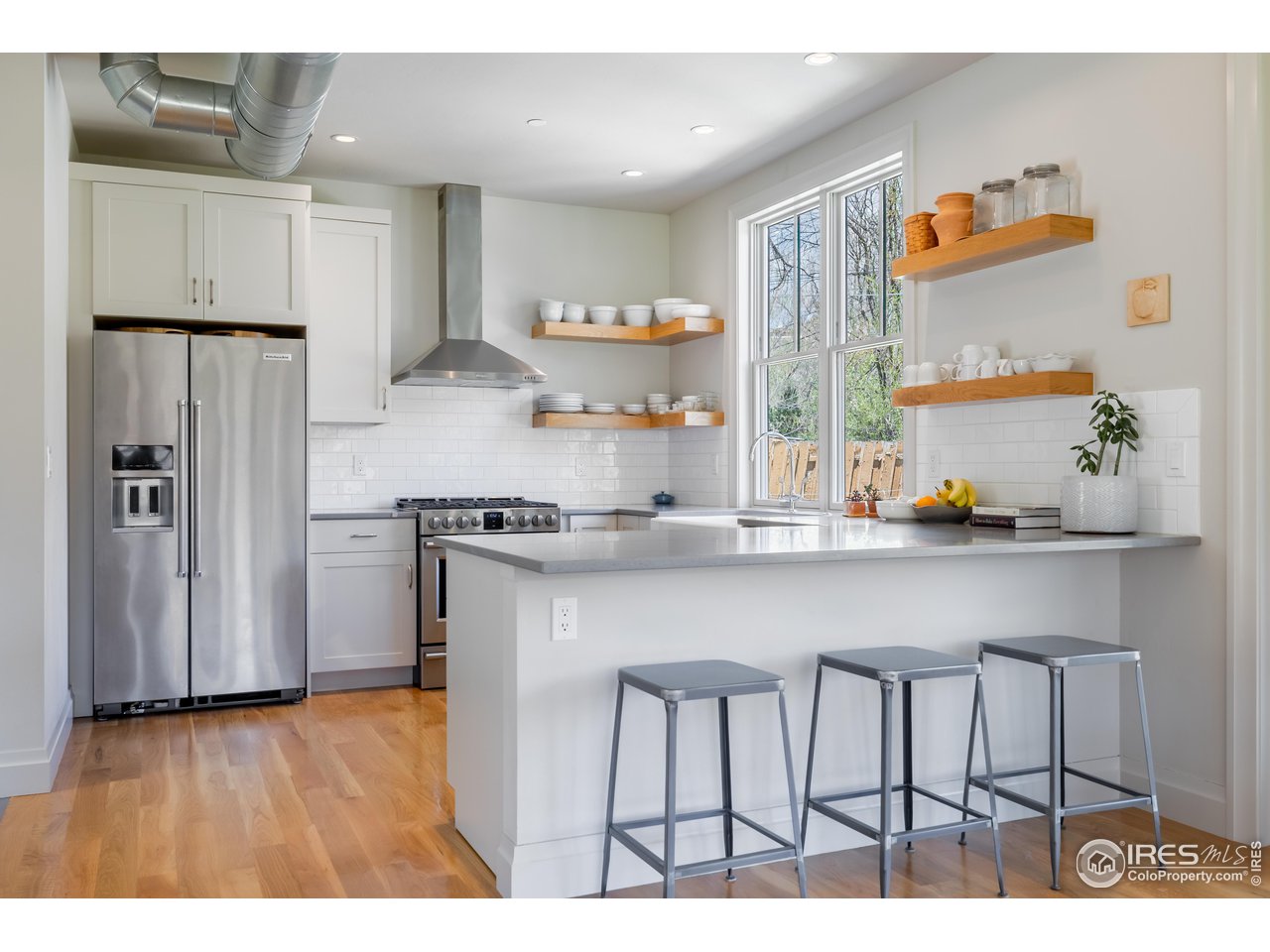 354 Apple Valley Road Lyons, CO 80540 - Photo 11 of 40 a kitchen with stainless steel appliances granite countertop a table chairs in it and wooden floors