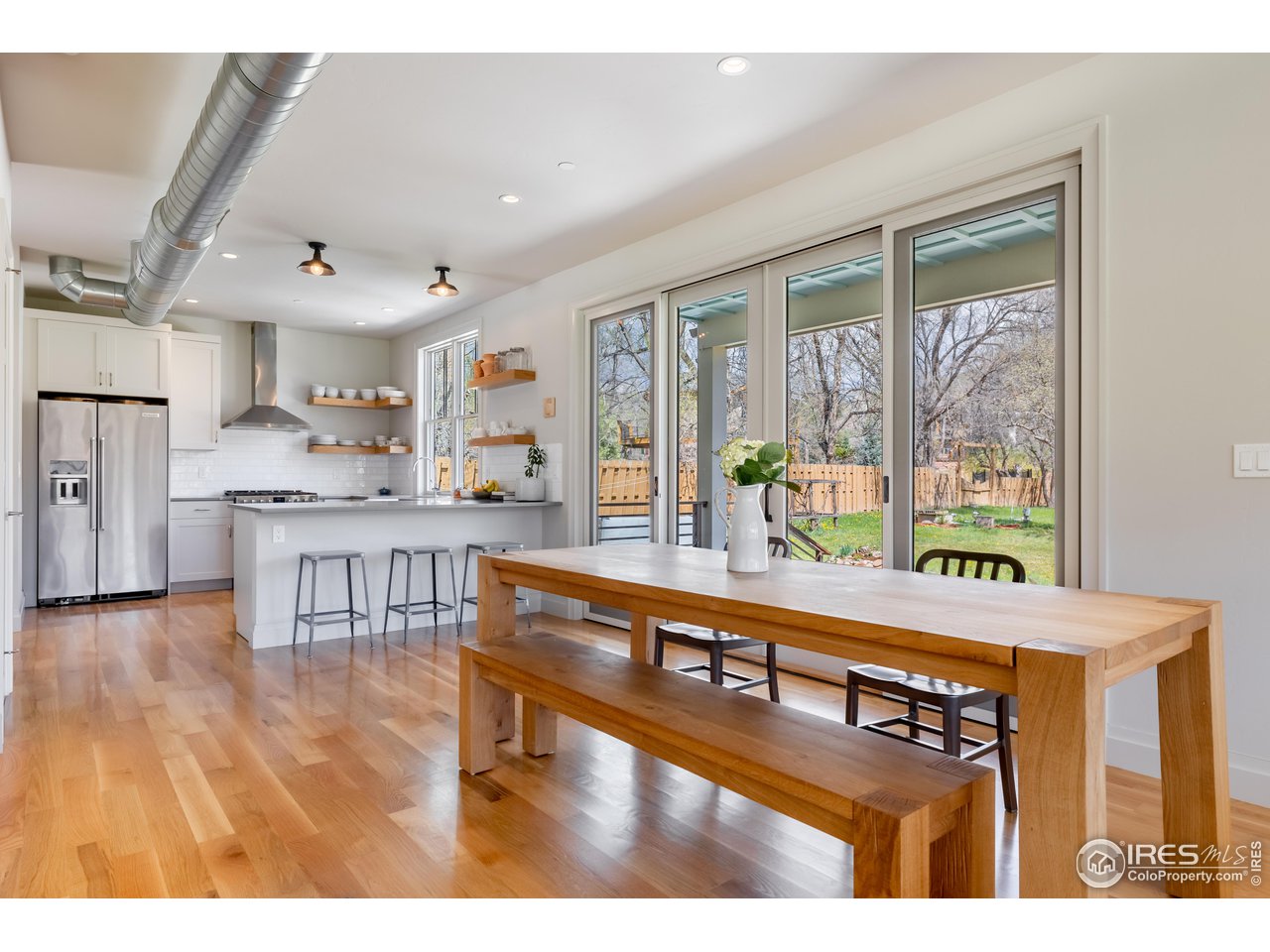 354 Apple Valley Road Lyons, CO 80540 - Photo 14 of 40 a living room with stainless steel appliances kitchen island granite countertop a refrigerator a stove a sink and a dining table with wooden floor