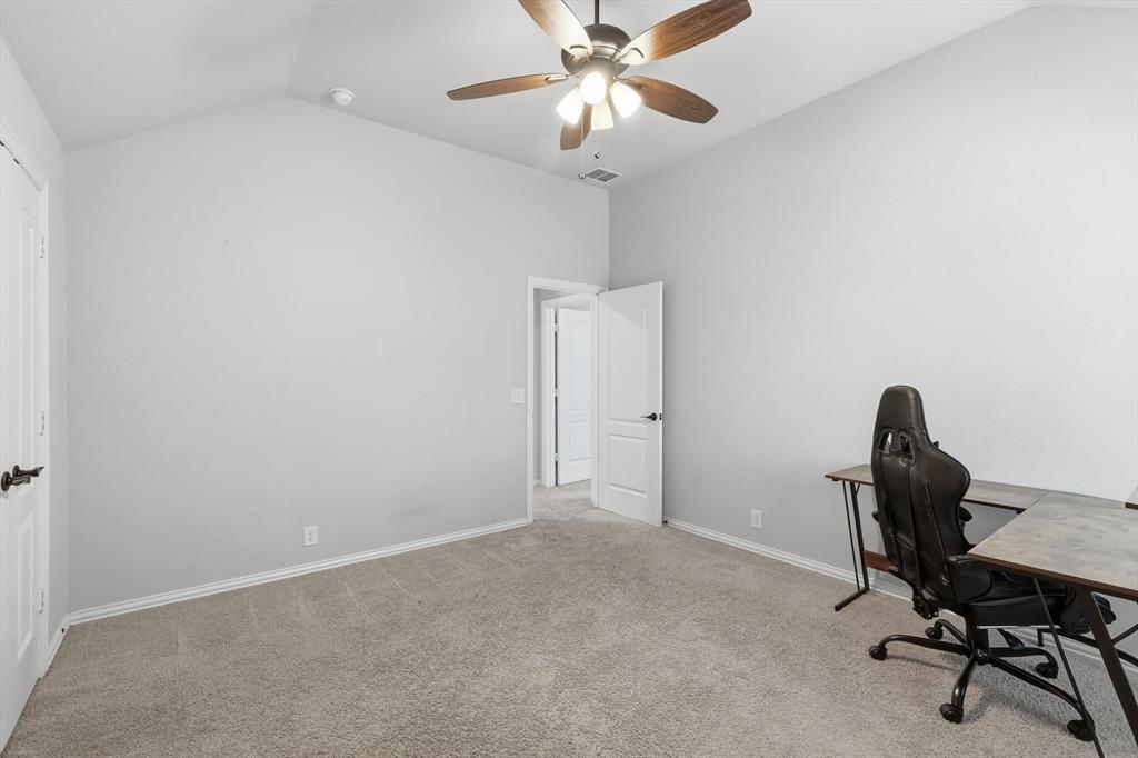 924 Timber Ridge Drive Justin, TX 76247 - Photo 29 of 32 Spacious room featuring vaulted ceilings, neutral-toned carpeting, light-colored walls, a ceiling fan with integrated lighting, and white trim