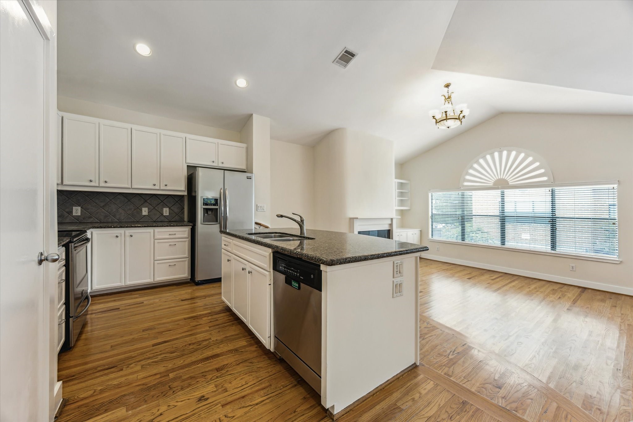 9829 Riddlelink Lane Houston, TX 77025 - Photo 6 of 22 Modern kitchen with granite counters, stainless appliances, and a central island overlooking the living room.