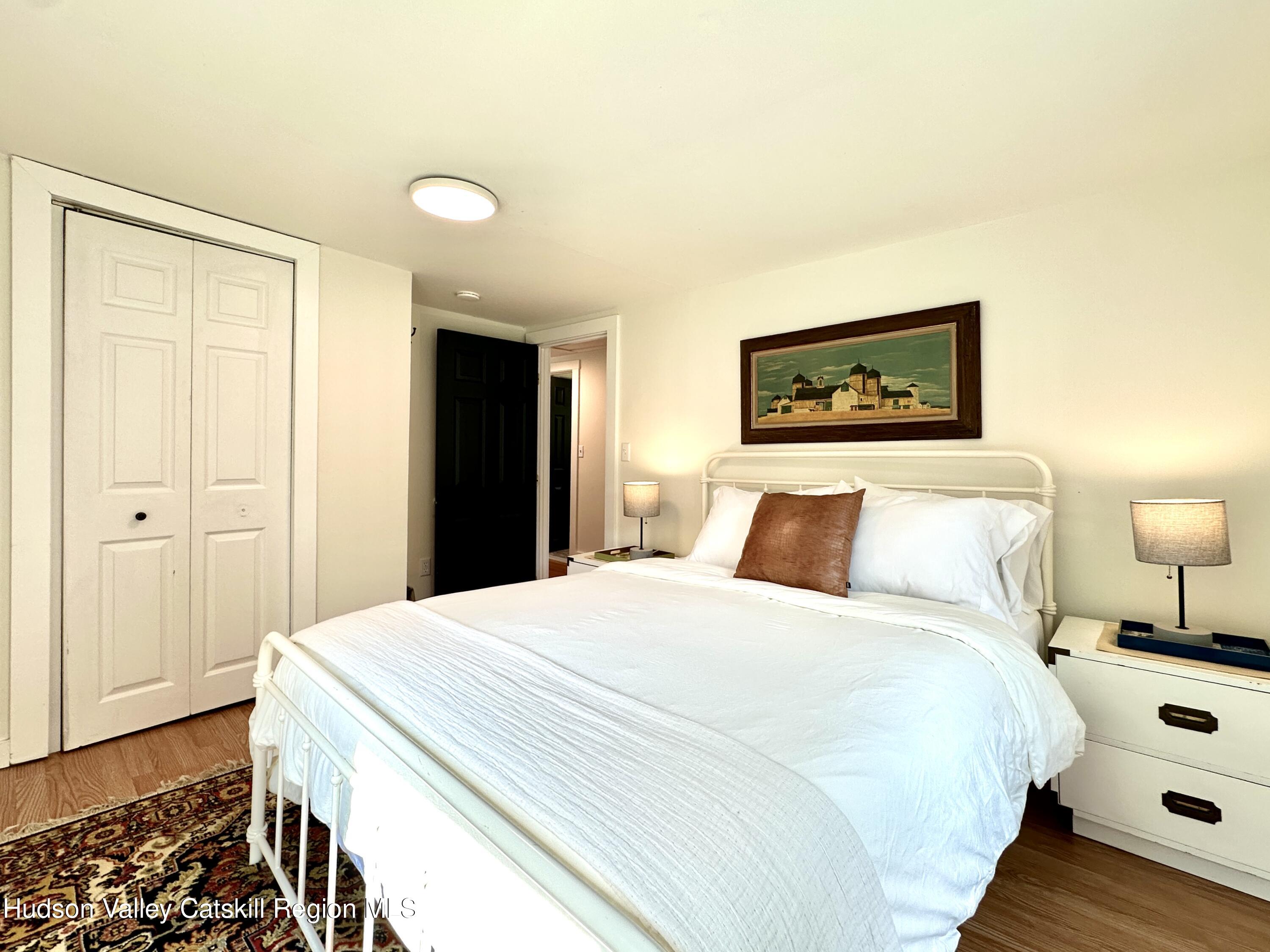 209 Griffin Road East Jewett, NY 12424 - Photo 15 of 34 a spacious bedroom with a bed and a lamp on dresser