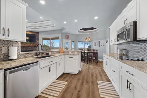 a large kitchen with stainless steel appliances kitchen island granite countertop a sink and cabinets