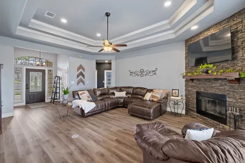 a living room with furniture a fireplace and a chandelier