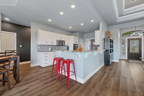 a kitchen with stainless steel appliances kitchen island granite countertop a refrigerator and a stove top oven