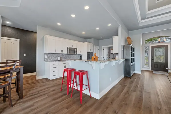 a kitchen with stainless steel appliances kitchen island granite countertop a refrigerator and a stove top oven