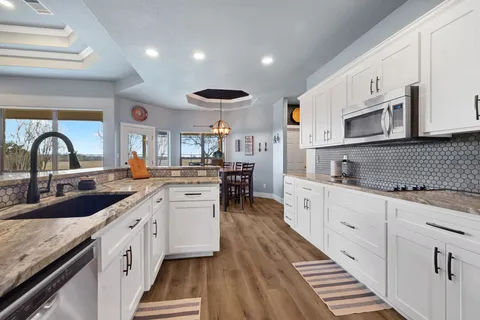 a kitchen with sink a stove and cabinets