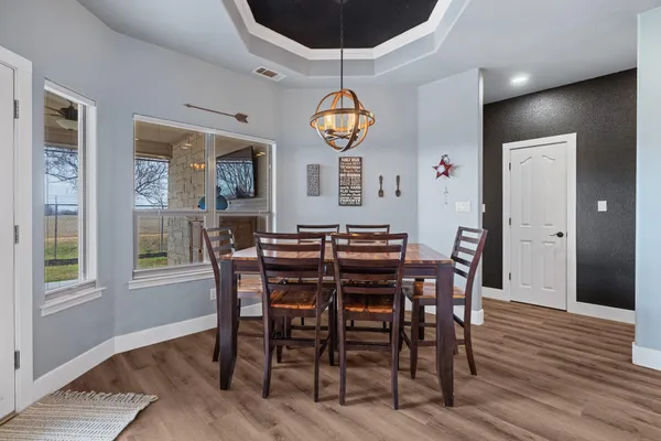 a view of a dining room with furniture wooden floor and chandelier