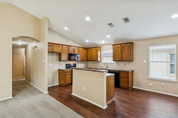 a kitchen with stainless steel appliances granite countertop a refrigerator a sink a stove and oven