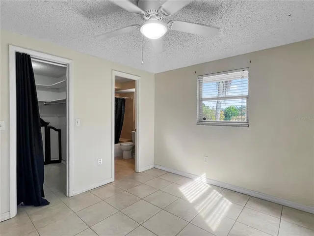 an empty room with closet and a chandelier fan