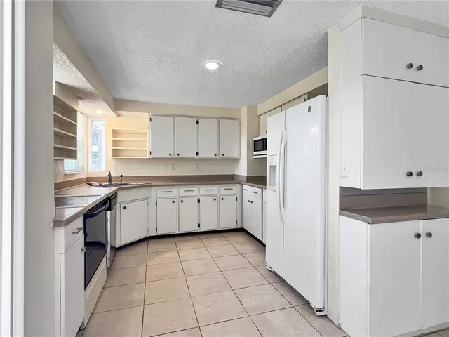 a kitchen with a sink a refrigerator and cabinets