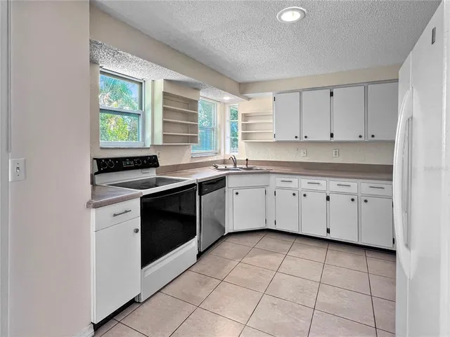 a kitchen with a stove sink and cabinets