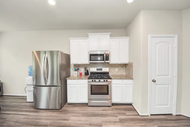 a kitchen with a refrigerator and a stove top oven