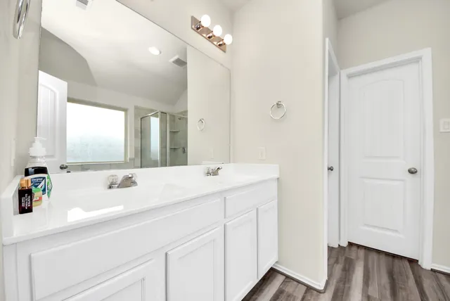 a bathroom with a double vanity sink a mirror and a