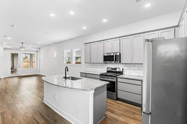 a kitchen with stainless steel appliances granite countertop a sink stove and refrigerator
