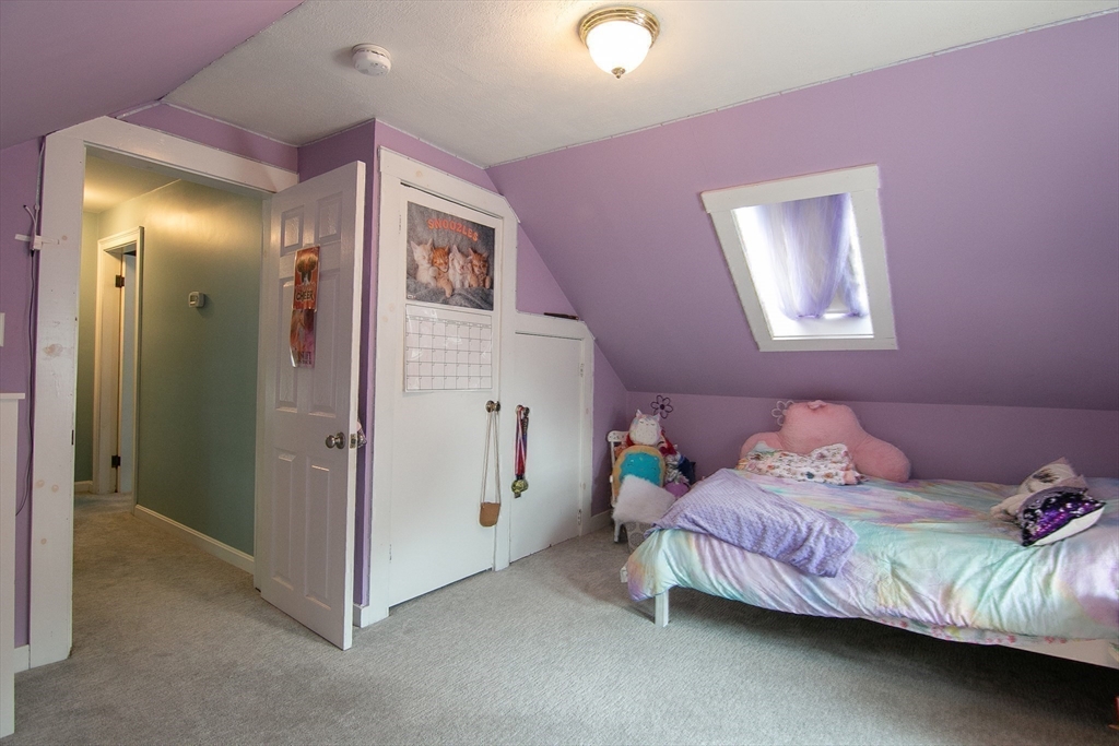 10 Makepeace Street Saugus, MA 01906 - Photo 24 of 36 a bedroom with a bed and a chandelier