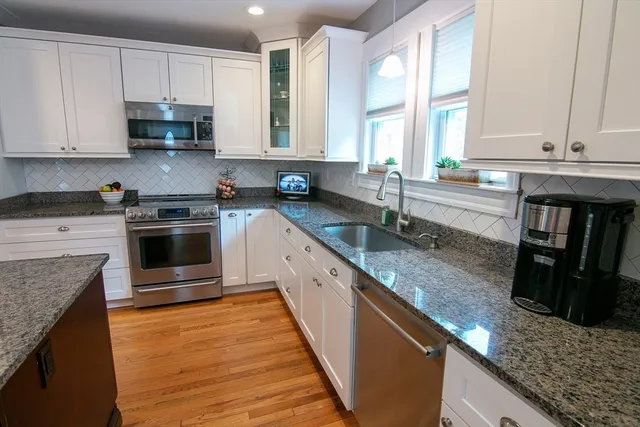 a kitchen with stainless steel appliances granite countertop a stove a sink and a microwave