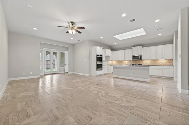 a kitchen with kitchen island granite countertop a stove a sink a counter top space and cabinets