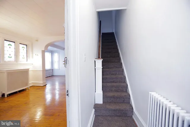 a view of a hallway with wooden floor and staircase