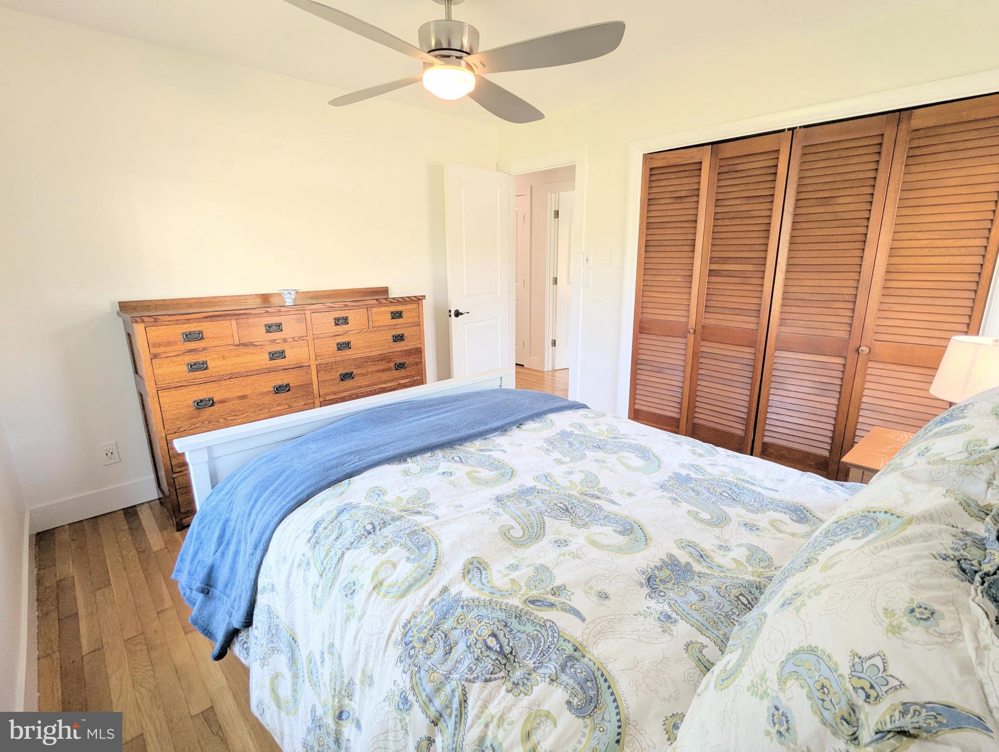 504 Main Street Stevensville, MD 21666 - Photo 22 of 30 a bedroom with a bed and a chandelier