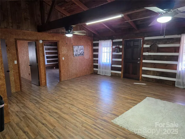 a view of an empty room with furniture and a kitchen