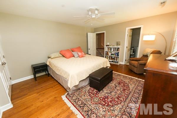 5227 Knollwood Road Raleigh, NC 27609 - Photo 8 of 12 a bedroom with a large bed and a chandelier